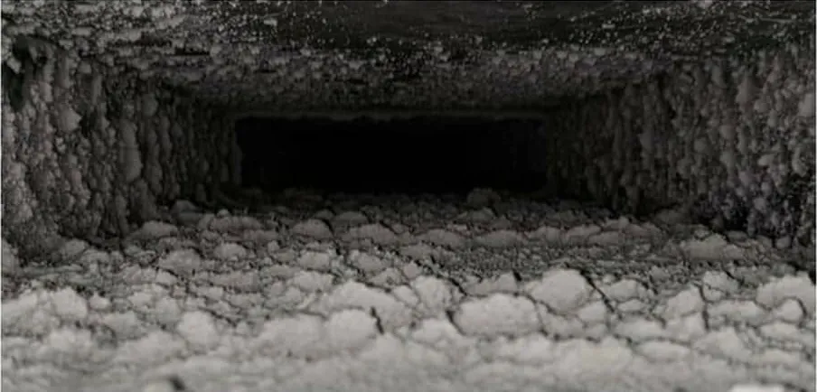 Air duct interior before cleaning, packed with dust