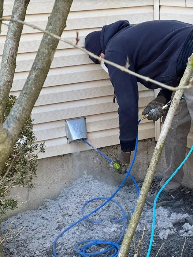 Technician clearing lint from an exterior dryer vent